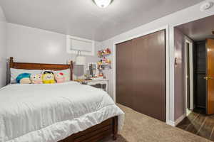 Carpeted bedroom featuring a closet and baseboards