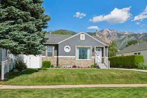 View of front of property with stone siding, entry steps, stucco siding, a shingled roof, and a mountain view