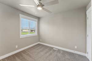 Unfurnished room with carpet floors, baseboards, and a ceiling fan