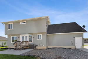 Back of house featuring central AC, stucco siding, and a shingled roof