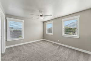 Carpeted empty room with baseboards and ceiling fan