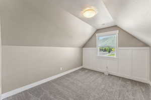 Additional living space featuring carpet flooring, lofted ceiling, and baseboards