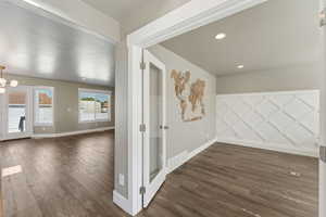 Unfurnished room with dark wood-style floors, baseboards, a chandelier, and recessed lighting