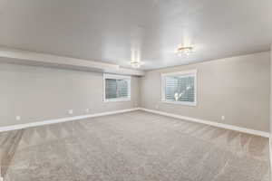 Empty room featuring baseboards and carpet