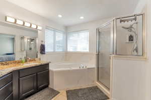 Bathroom with vanity, a bath, a shower stall, tile patterned floors, and recessed lighting