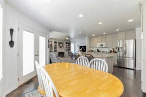 Dining room with a glass covered fireplace, recessed lighting, ceiling fan, baseboards, and dark wood finished floors