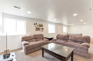 Living room featuring carpet, recessed lighting, and baseboards