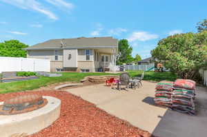 View of patio featuring a fire pit, a playground, and a garden