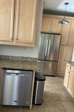 Kitchen with stainless steel appliances, maple cabinetry, granite counters, and  tile flooring