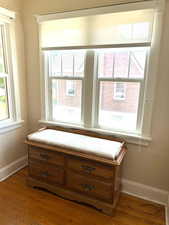 Detailed view of wood finished floors, baseboards, and an abundance of windows