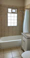 Bathroom featuring vanity, tile patterned flooring, toilet, and shower / bath combination with curtain