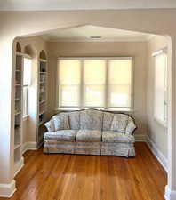 Living room featuring arched walkways, hardwood / wood-style flooring, and healthy amount of natural light