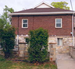 View of home's exterior featuring brick siding, stone siding, and patio/terrace