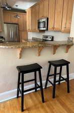 Kitchen and Breakfast Bar featuring stainless steel appliances, granite counters, and pendant lighting