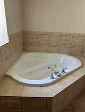Bathroom with a jetted tub and tile patterned floors