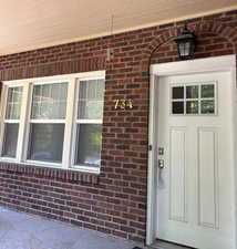 View of exterior entry with brick siding
