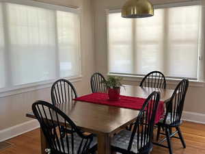 Dining Room featuring plenty of natural light, finished wood floors, a textured ceiling, and baseboards