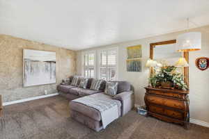 Living room featuring carpet, baseboards, and lofted ceiling