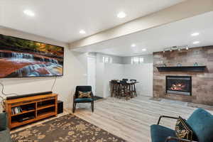 Living room featuring wood finished floors, rail lighting, baseboards, a fireplace, and recessed lighting