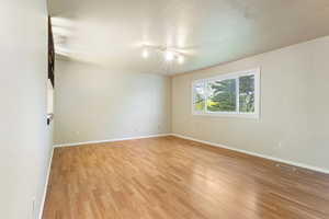 Spare room featuring light wood-style floors and baseboards