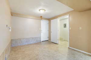 Unfurnished room featuring electric panel, tile patterned flooring, and a textured ceiling