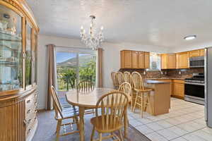 Dining space with a textured ceiling, a chandelier, and a mountain view