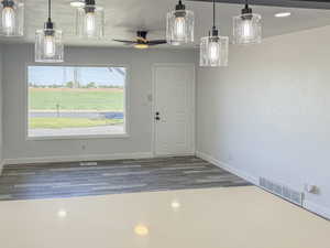 Unfurnished dining area with baseboards, wood finished floors, and ceiling fan