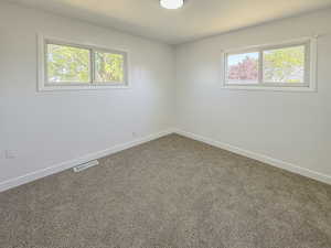 Carpeted empty room featuring baseboards