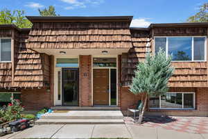 Entrance to property featuring mansard roof and brick siding