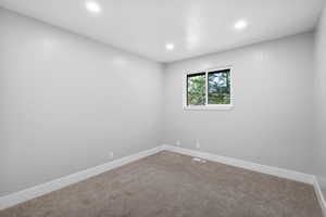 Carpeted spare room with recessed lighting and baseboards