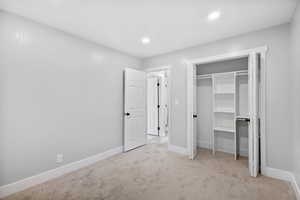 Unfurnished bedroom featuring carpet, baseboards, recessed lighting, and a closet