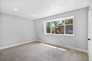 Carpeted spare room with baseboards and recessed lighting