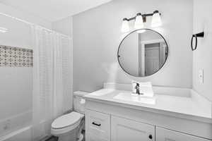 Bathroom with vanity, toilet, and shower / tub combo