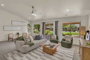 Living room with ceiling fan, recessed lighting, baseboards, lofted ceiling, and light colored carpet