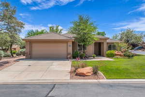 View of front facade with stone siding, stucco siding, concrete driveway, an attached garage, and a front yard