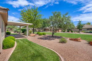 View of green lawn with a patio area