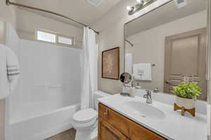 Bathroom with shower / bathtub combination with curtain, vanity, toilet, and tile patterned floors
