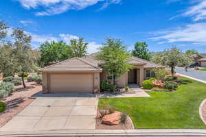 View of front of house with driveway, a garage, stone siding, stucco siding, and a front lawn