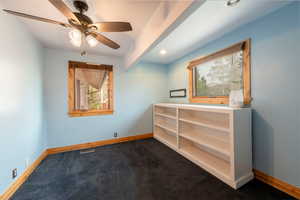 Spare room featuring dark colored carpet, baseboards, ceiling fan, and recessed lighting
