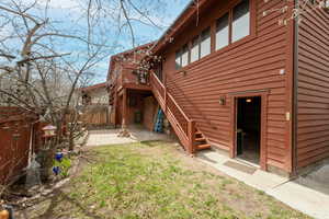 Rear view of property with a fenced backyard, stairs, and a wooden deck