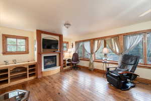 Home office featuring a fireplace, hardwood / wood-style floors, and baseboards