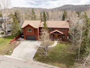 View of front of house featuring a porch, driveway, a chimney, and a front lawn