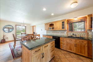 Kitchen with black dishwasher, backsplash, open shelves, a textured ceiling, and a center island
