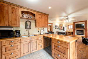 Kitchen with black appliances, a sink, butcher block counters, a peninsula, and ceiling fan