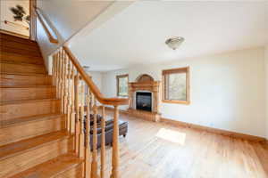 Staircase with baseboards, a premium fireplace, and wood finished floors