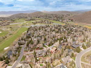 View of property location with nearby suburban area, a golf course, and a water and mountain view