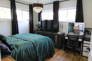 Bedroom with light wood-style flooring and a chandelier