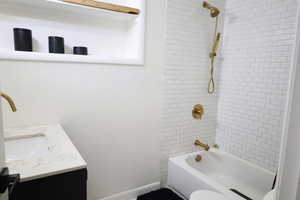 Bathroom featuring vanity,  shower combination, toilet, and baseboards