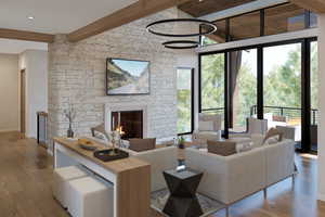 Living area with beam ceiling, healthy amount of natural light, wood finished floors, baseboards, and a fireplace