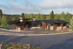 View of building exterior featuring an attached garage, asphalt driveway, and a forest view
